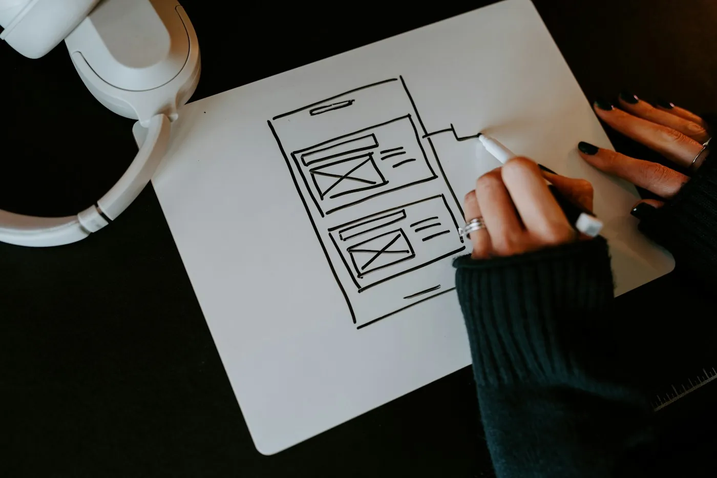 Designer sketching user flows and wireframes on paper